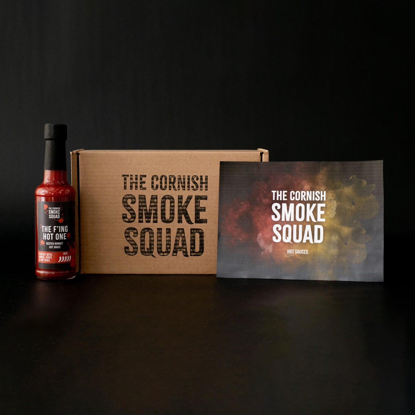 F'ing hot scotch bonnet hot sauce stood next to the cornish smoke squad giftbox