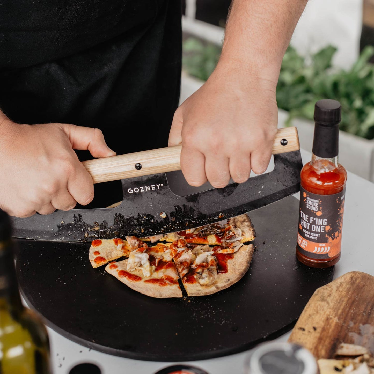 Flatbread with scotch bonnet hot sauce gets sliced using a Gozney knife