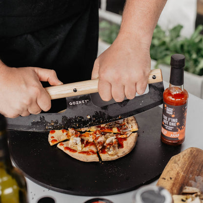 Flatbread with scotch bonnet hot sauce gets sliced using a Gozney knife